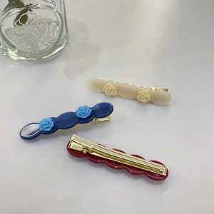 Vintage acetate rose hair clips in cream, navy blue, and deep red with gold metal duckbill