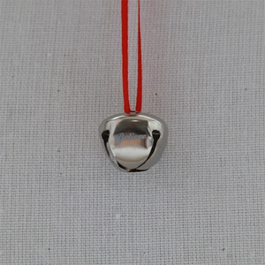 Detailed macro view of a silver sleigh bell engraved with 'Believe' and a red ribbon