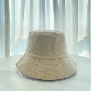 Detail of cream terry cloth bucket hat texture and soft fabric on marble surface