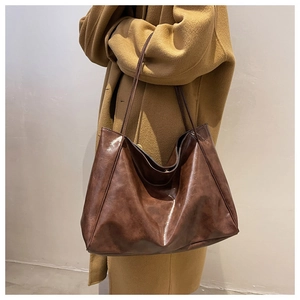 Macro view of minimalist brown leather tote bag texture and soft shoulder strap detail