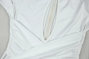 Detail of white deep V-neckline with hidden zipper and ruched fabric texture on jumpsuit
