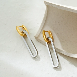 Detailed close-up of 18K gold and silver two-tone stainless steel long drop earrings