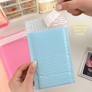 Detail of pink and blue bubble mailer showing the self-adhesive sealing strip and texture