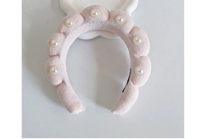 Pink plush cloud headband with pearl embellishments and a soft braided texture detail