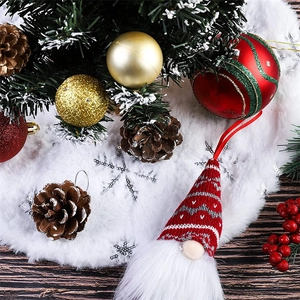 Close-up of plush white Christmas tree skirt with silver snowflakes and festive ornaments