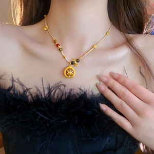 Detail of beaded necklace with gold Buddha pendant and colorful natural stone beads