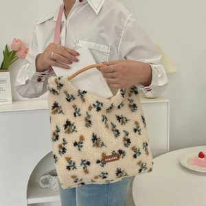 Detail of plush tote bag showing floral patterns and orange woven rope handle