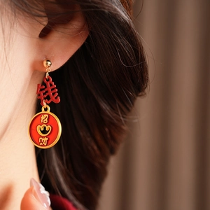 Macro shot of vintage enamel fortune bag earrings with red Zhao Cai characters