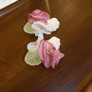 Sweet pink silk flower earrings with resin roses and textured leaf details on wood
