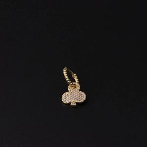 Close-up of golden club-shaped earring with pavé-set zircons and beaded ring detail