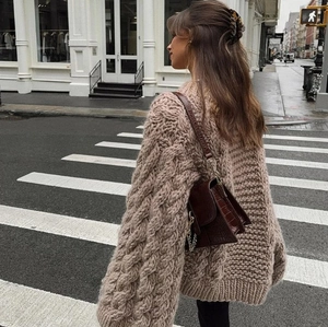 Oversized round neck knit sweater with bell sleeves in earthy oatmeal tone on street