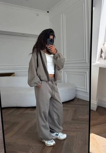 Détail d'un ensemble hoodie gris oversize et d'un pantalon large avec un crop top blanc
