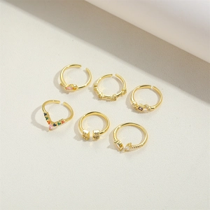 Flat lay of six diverse gold-plated adjustable rings with colorful cubic zirconia details
