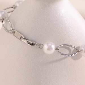 Macro shot of 18K silver-plated stainless steel chain with pearl and K18 hallmark detail