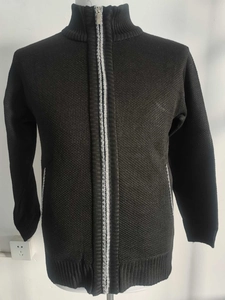 Detail of black knit cardigan featuring a full zipper, stand collar, and ribbed cuffs