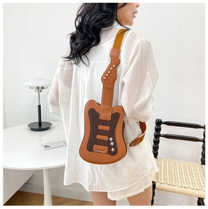 Detailed view of guitar shaped crossbody bag with star studs on a female model