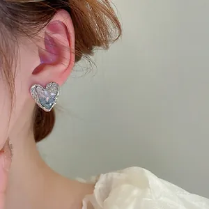 Elegant heart-shaped silver earrings with vintage relief and light blue crystal stone