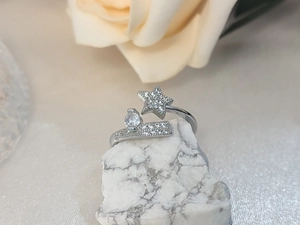Detailed view of pentagram star ring with pavé diamonds and zircon on white stone
