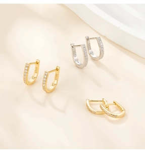 Close-up of S925 sterling silver horseshoe earrings with cubic zirconia in gold and silver
