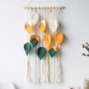 Detailed handmade woven cotton tapestry featuring colorful leaf designs on a wooden stick