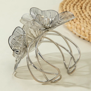 Detailed macro view of silver hollow floral bracelet with sparkling crystal centers