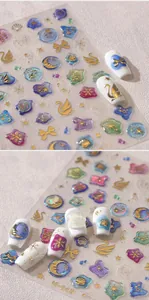 Detail showing 3D bronzing nail stickers with swan, moon, and shell patterns