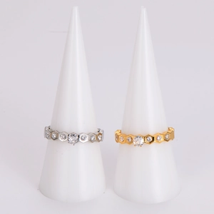 Diamond-set honeycomb design ring in gold and silver finish on white jewelry display