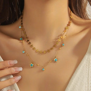 Detail of layered gold necklace with blue star pendants and turquoise evil eye charms