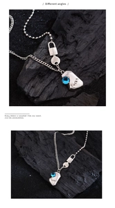 Detail view of silver Lucky necklace with blue gemstone on textured black rock