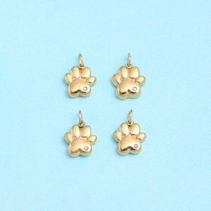Detailed close-up of four gold cat paw charms with sparkling crystal rhinestones