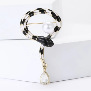 Detail of snake brooch with black and white enamel, large white pearl and crystal drop