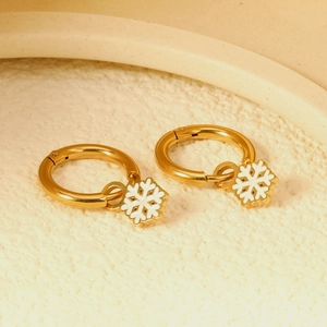 Gold Christmas hoop earrings with white enamel snowflake charms on a white background