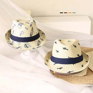 Detailed view of woven straw sun hats for children with surf and shark patterns