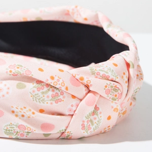 Close-up of pink floral knotted headband showing fabric texture and Easter egg patterns