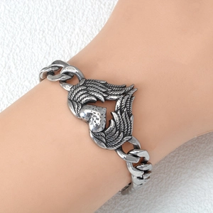 Silver stainless steel Cuban chain bracelet featuring a heart with angel wings on wrist