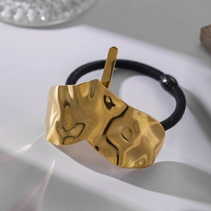 Minimalist black elastic hair tie featuring a textured gold hammered metal charm buckle