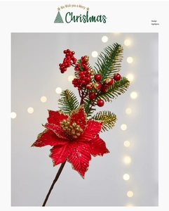 Detail of faux pine branch with red poinsettia, berries, and gold glitter accents