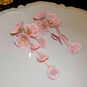 Macro detail of pink layered flower petal tassel earrings with sparkling rhinestones