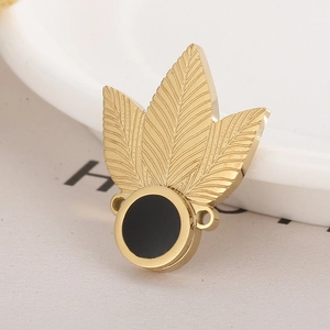 Detail of a golden leaf charm with black circular base and side holes on white background