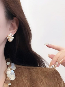 Gros plan de boucles d'oreilles perles fleurs avec cristaux pour un look luxueux chic