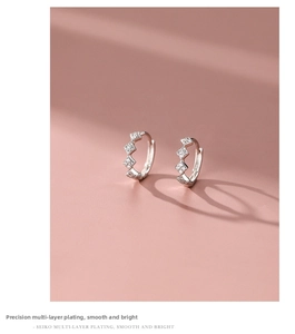 Detail shot of 925 silver hoop earrings with diamond rhombic pattern on pink background