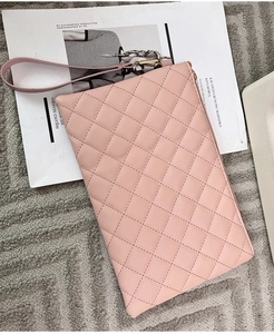 Gros plan de la pochette rose en similicuir matelassé avec fermeture éclair dorée