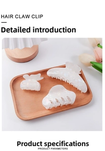 Detailed set of three pearlescent white hair claw clips in a wooden tray presentation