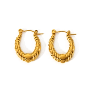 Détail macro de boucles d'oreilles en acier inoxydable doré 18K avec surface texturée