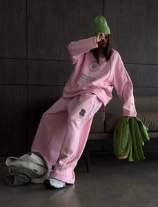 Detail of pink oversized sweatshirt with Group Studios print and matching wide-leg pants