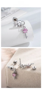 Macro detail of silver lock and key earrings featuring a pink star zircon and screw back