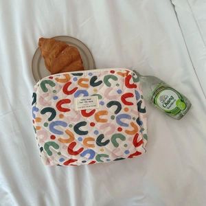 Top view of a floral quilted cotton cosmetic bag with multi-color horseshoe patterns