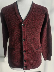 Detail der rot-schwarzen Strickjacke mit V-Ausschnitt, Frontknöpfen und strukturierten Taschen