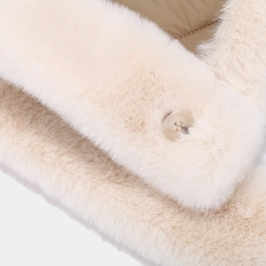 Detail of soft cream faux fur texture with matching button on a winter trapper hat