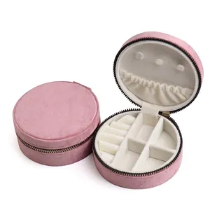 Portable round velvet jewelry organizer in dusty pink with compartments and zipper closure